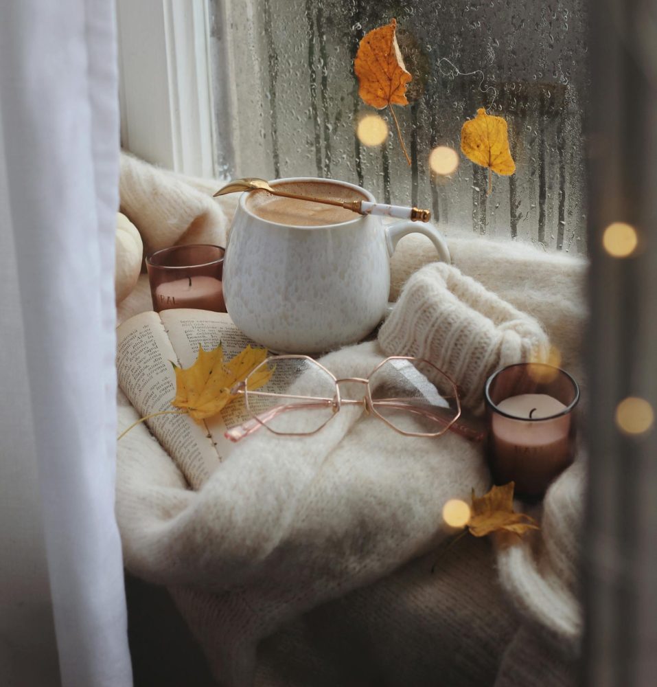 Coffee, glasses and sweater on book in autumn scene